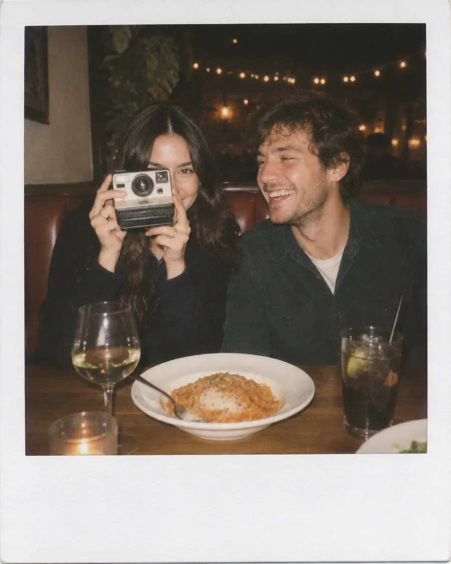 Una pareja joven se toma una foto instantánea en el restaurante